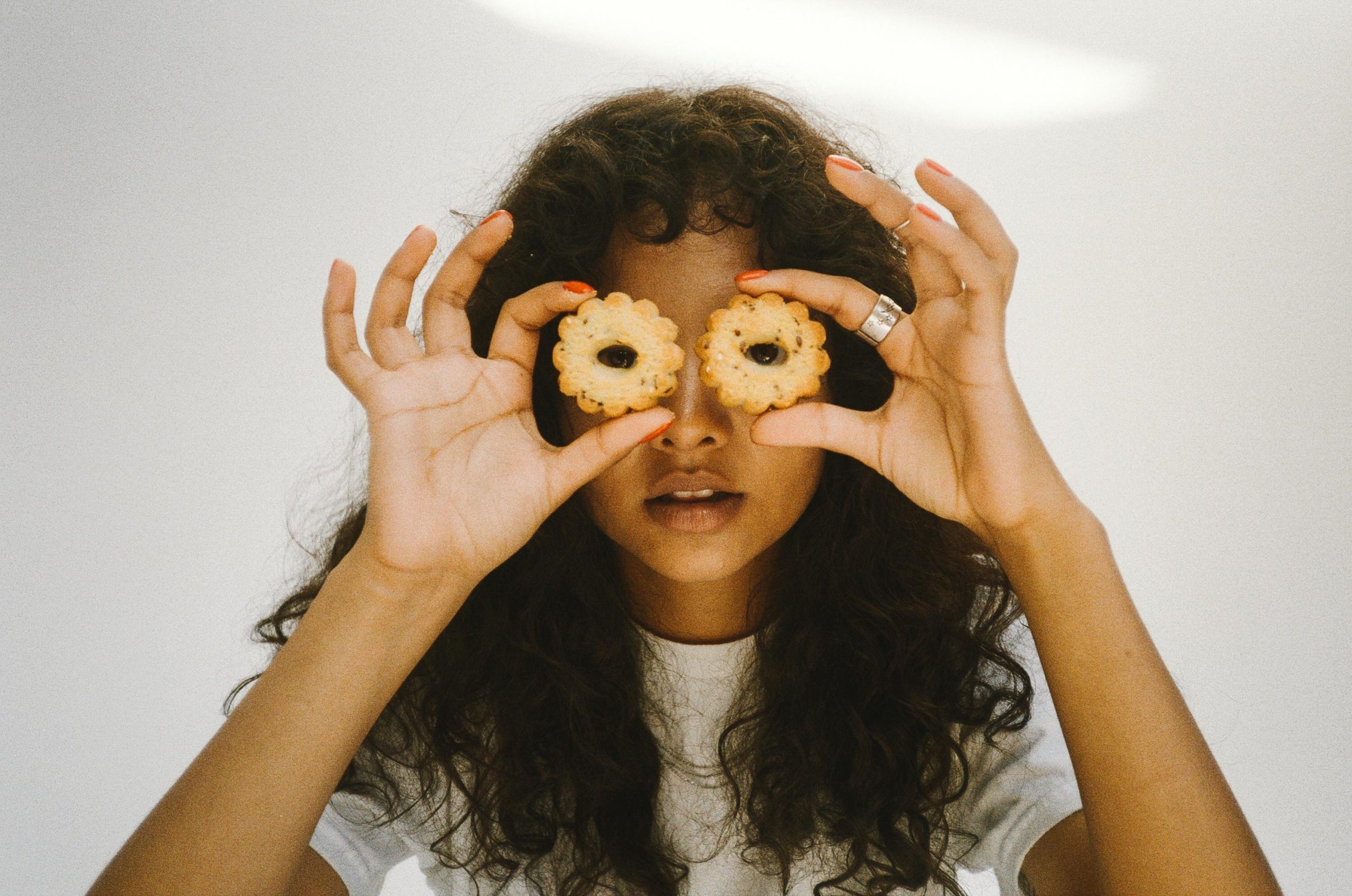 A Woman holding cookies over her eyes