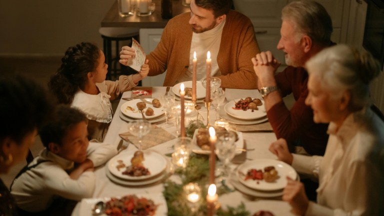 A family celebration around a table, laden with food.