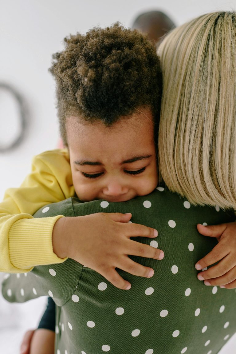 A young child hugs his mother