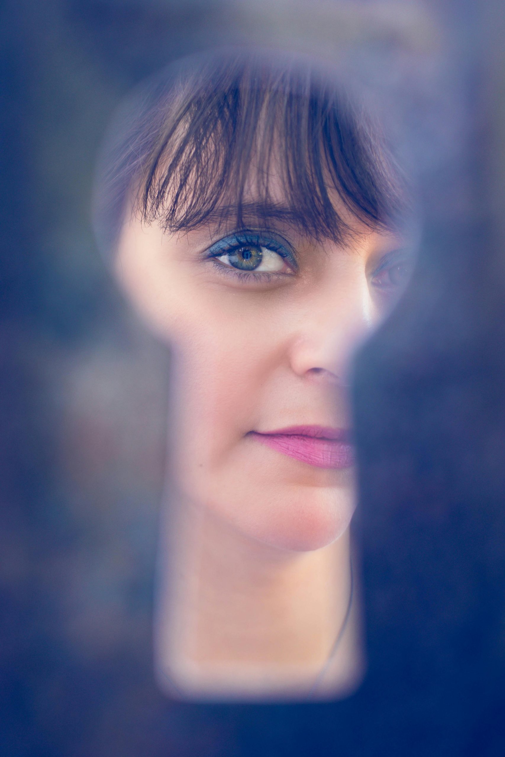 Image of a woman's face seen through a keyhole