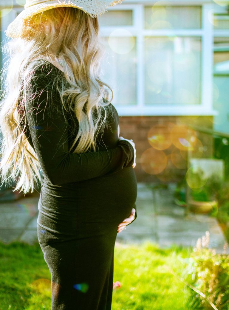 A pregnant woman holds her tummy.