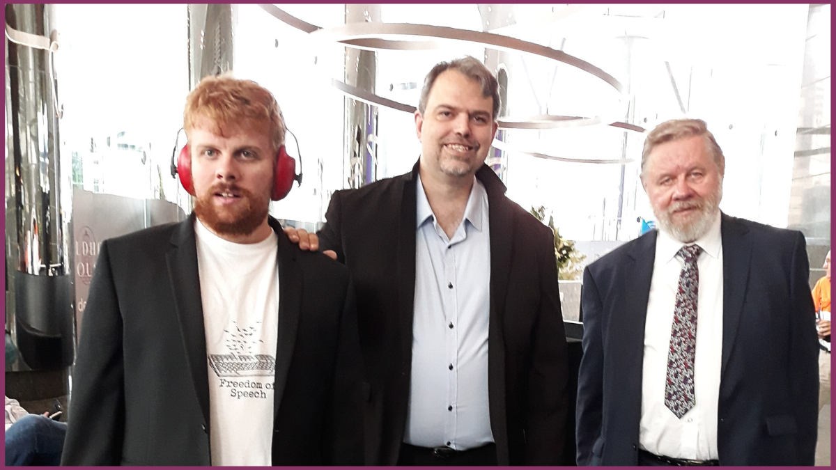 A photo of Autistic non-speaking advocate, Ben Davies, with his supporters.