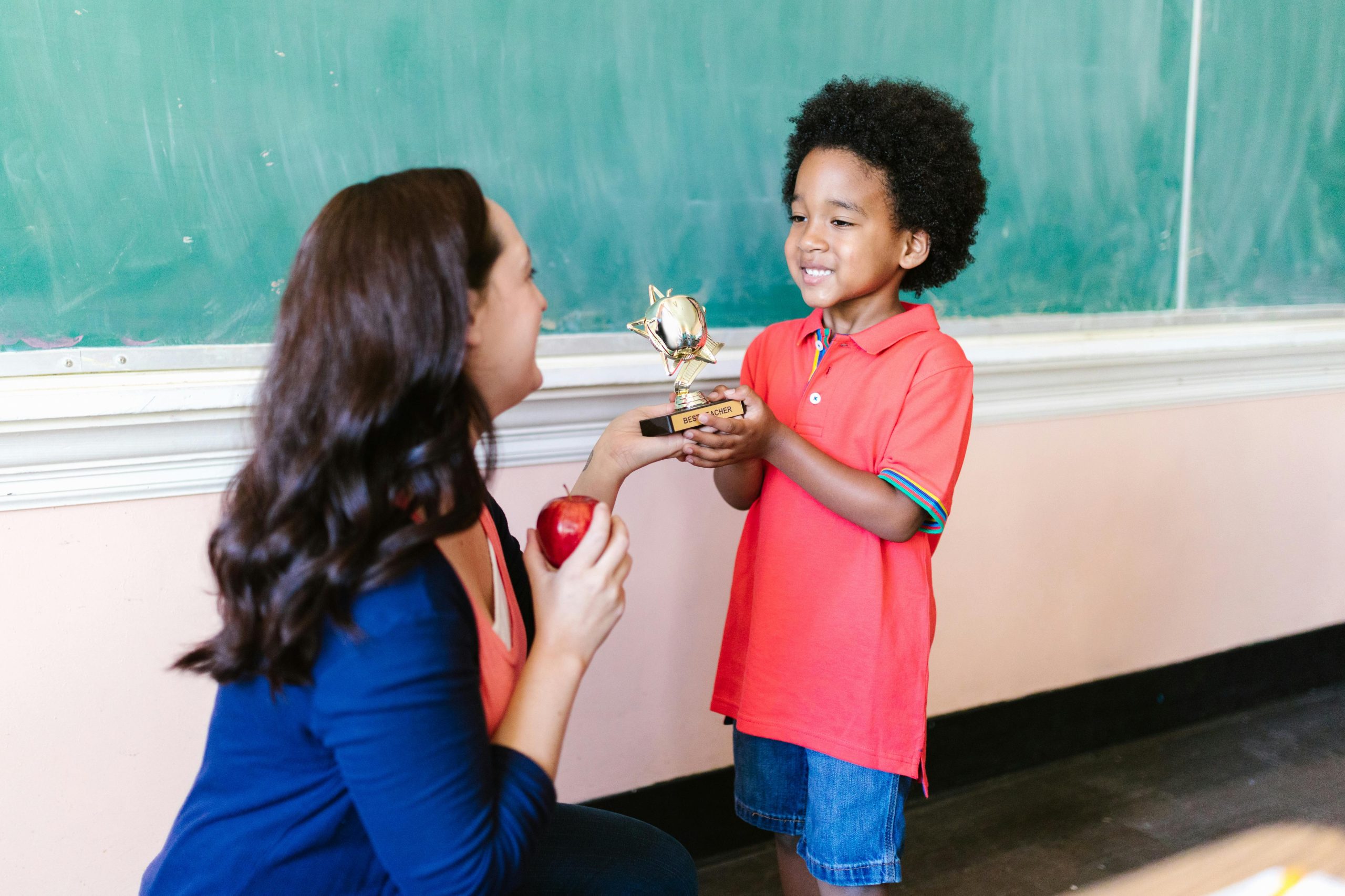 A little boy receives a trophy at school.