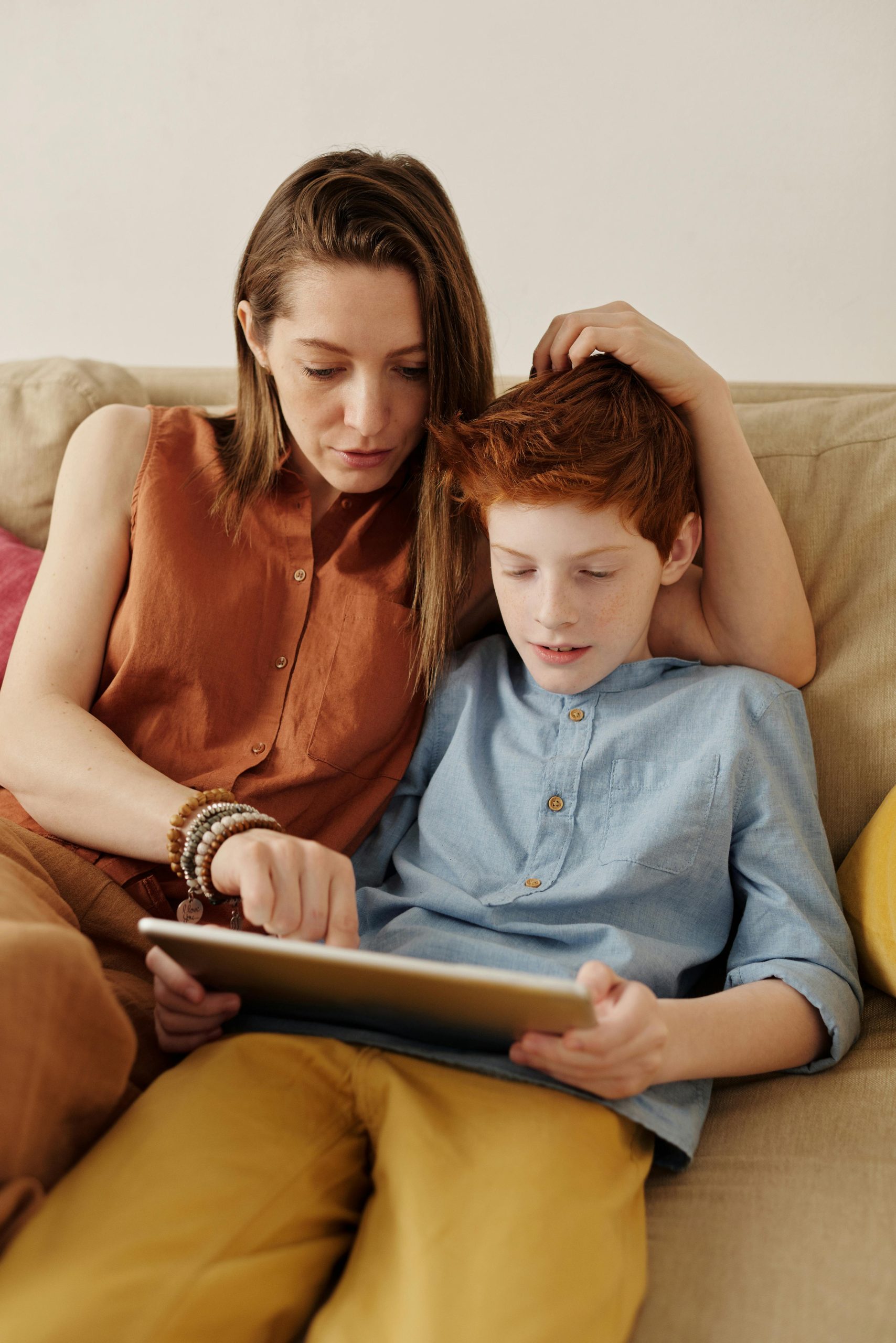 A mother helping her son with his ipad