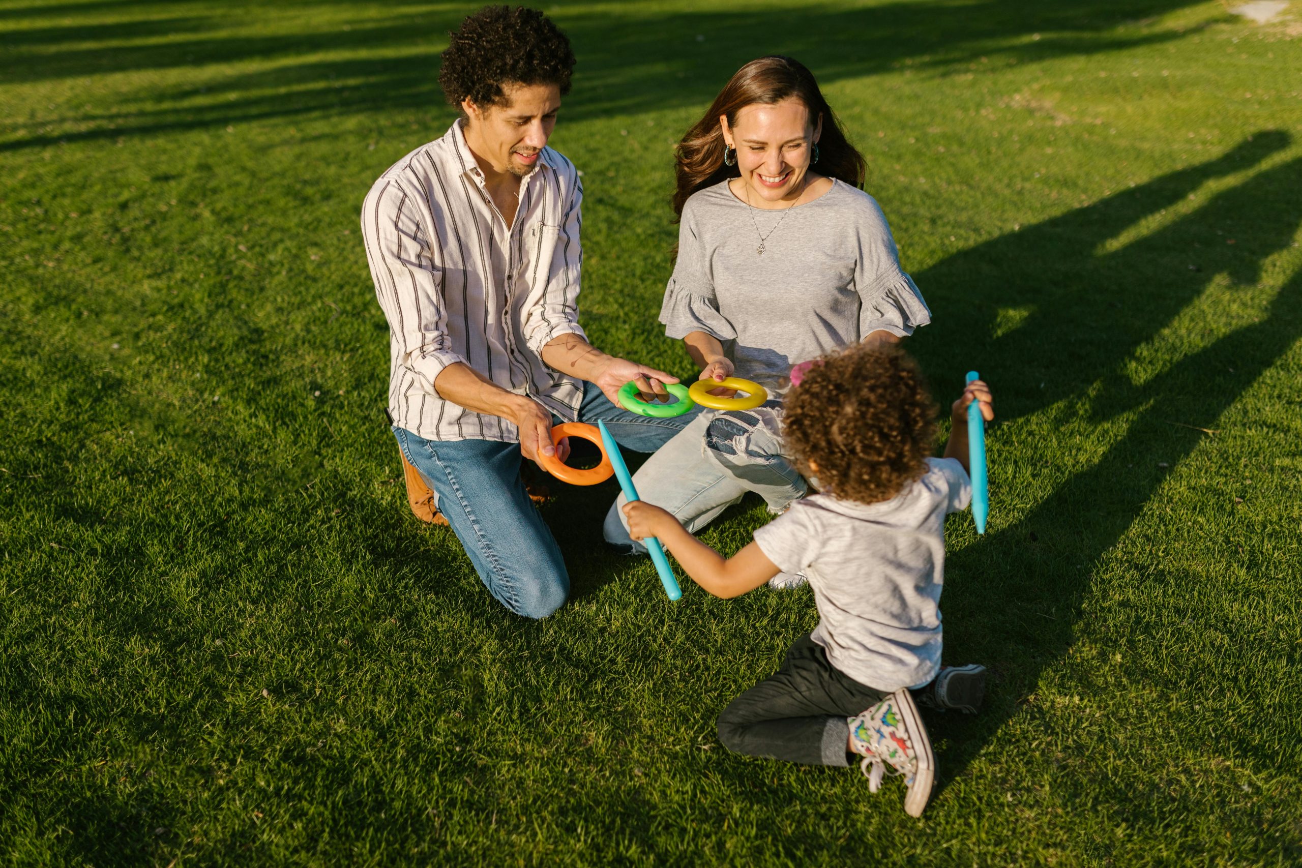 Parents playing in a park with their child