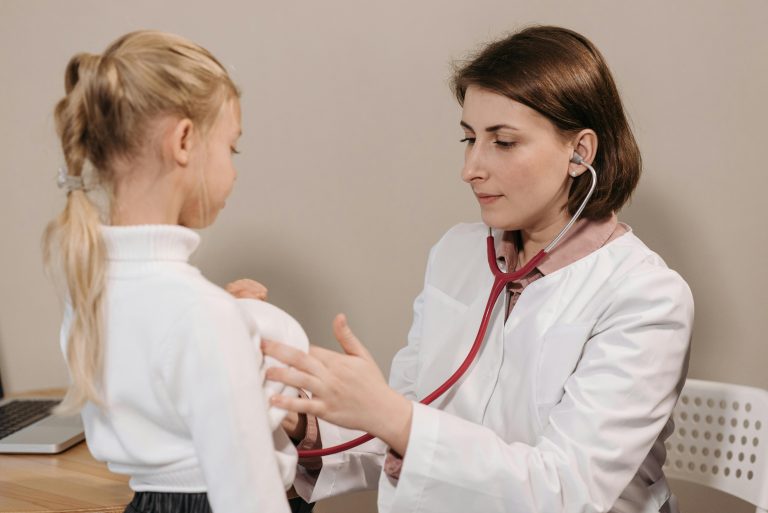 A doctor examining a little girl