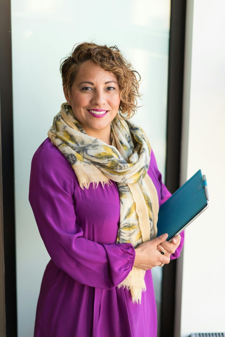 Woman smiling and holding a teal folder
