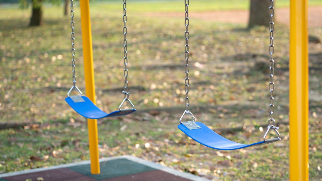 An empty swing set featuring two blue swings.