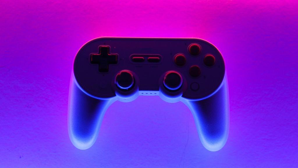 A gaming controller sits atop a pink, purple and blue background.
