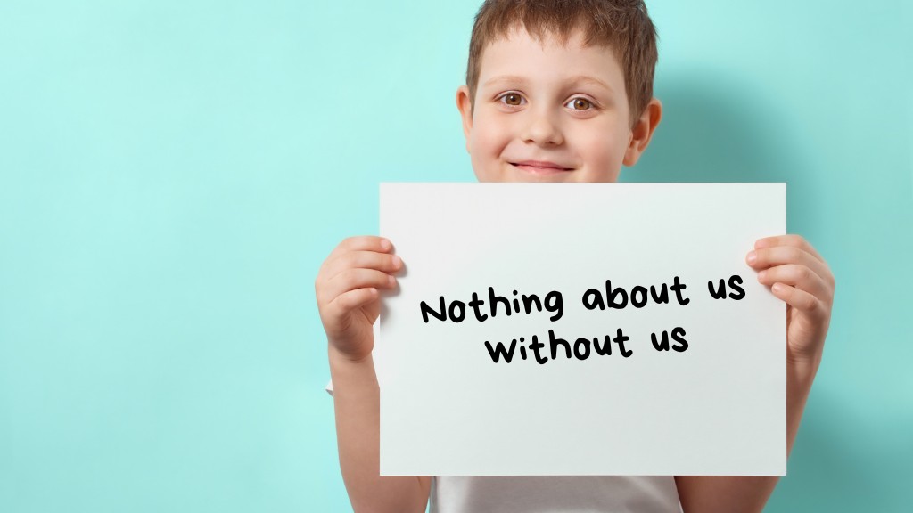 A blue background and a young boy holding a sign which reads, 