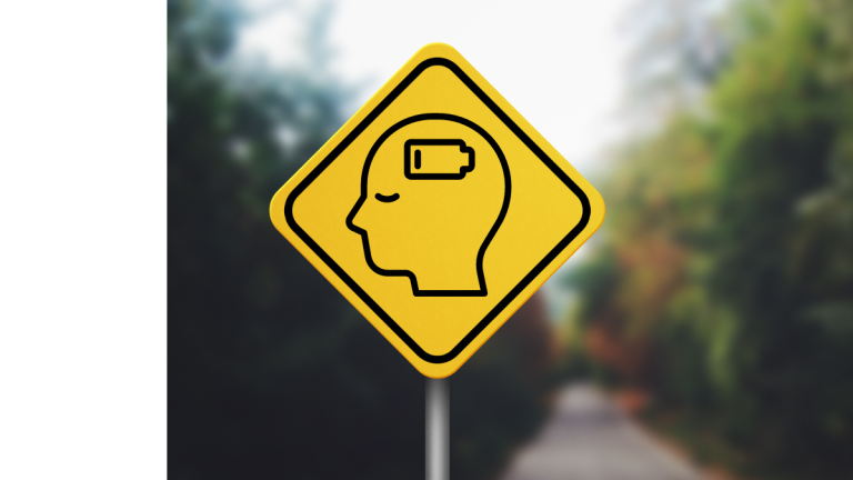 A photo of a yellow road sign with the icon of a person's head with a depleted battery in it.