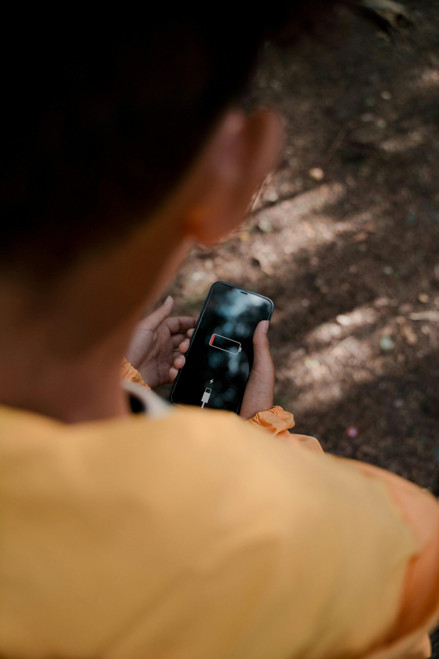A person holding a phone with a depleted battery