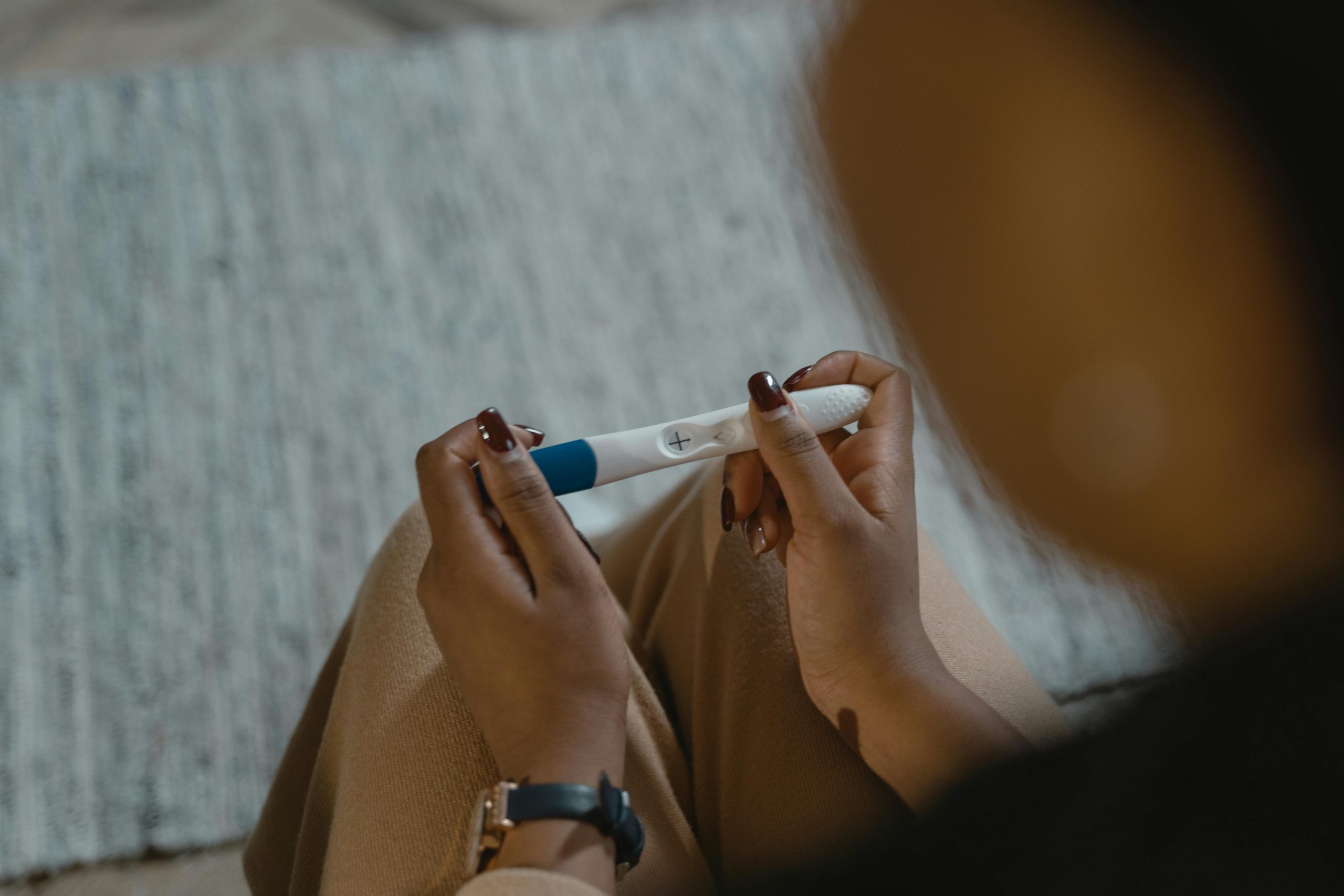 A woman holding a positive pregnancy test