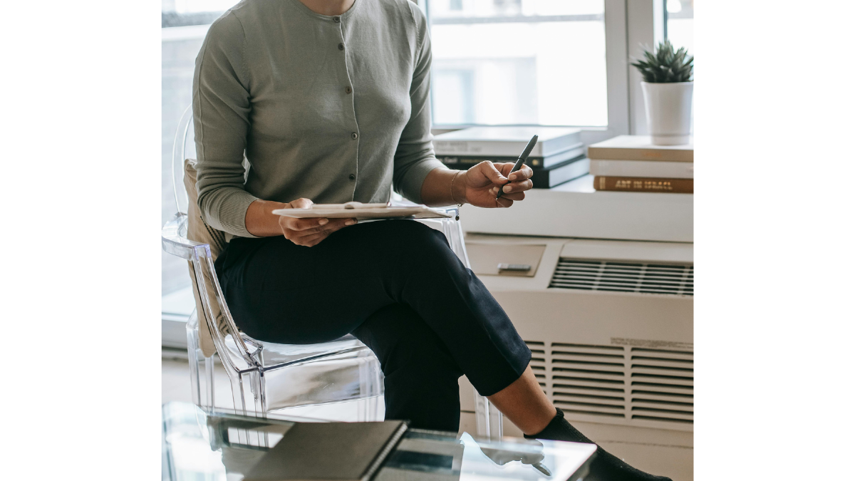 A photo of a psychologist, sitting in her office, taking notes.