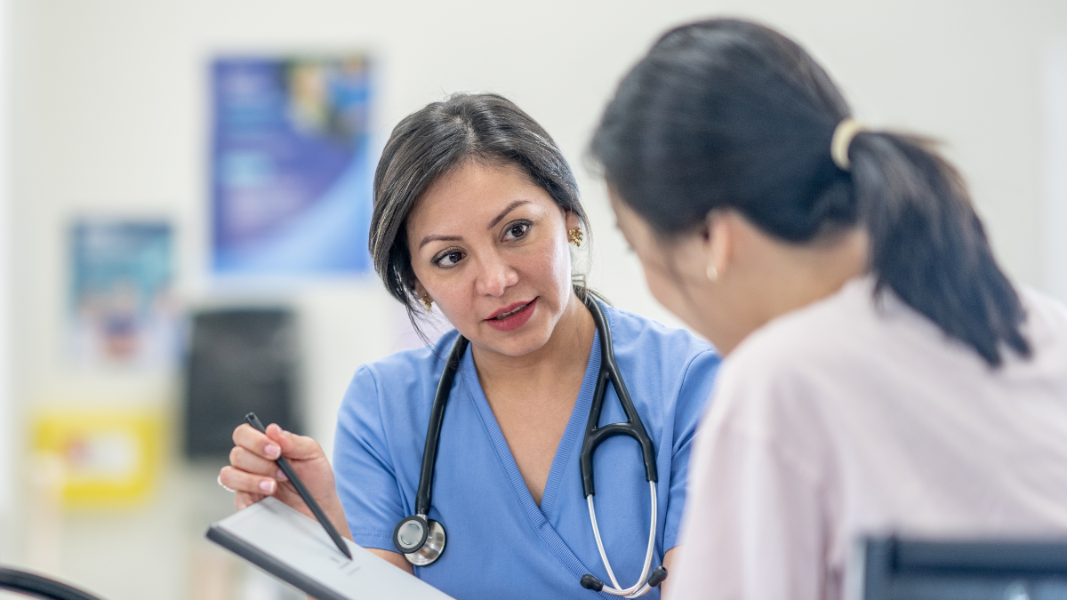 A female doctor shares the results of a report with a female patient.