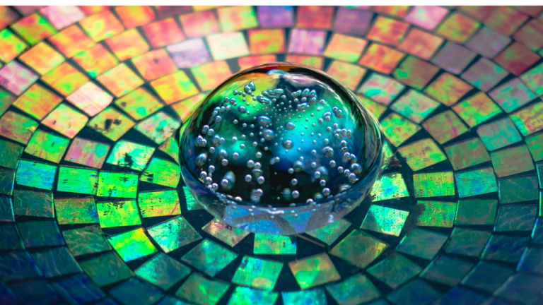 A colourful kaleidescope image with a luminescent marble in the middle.